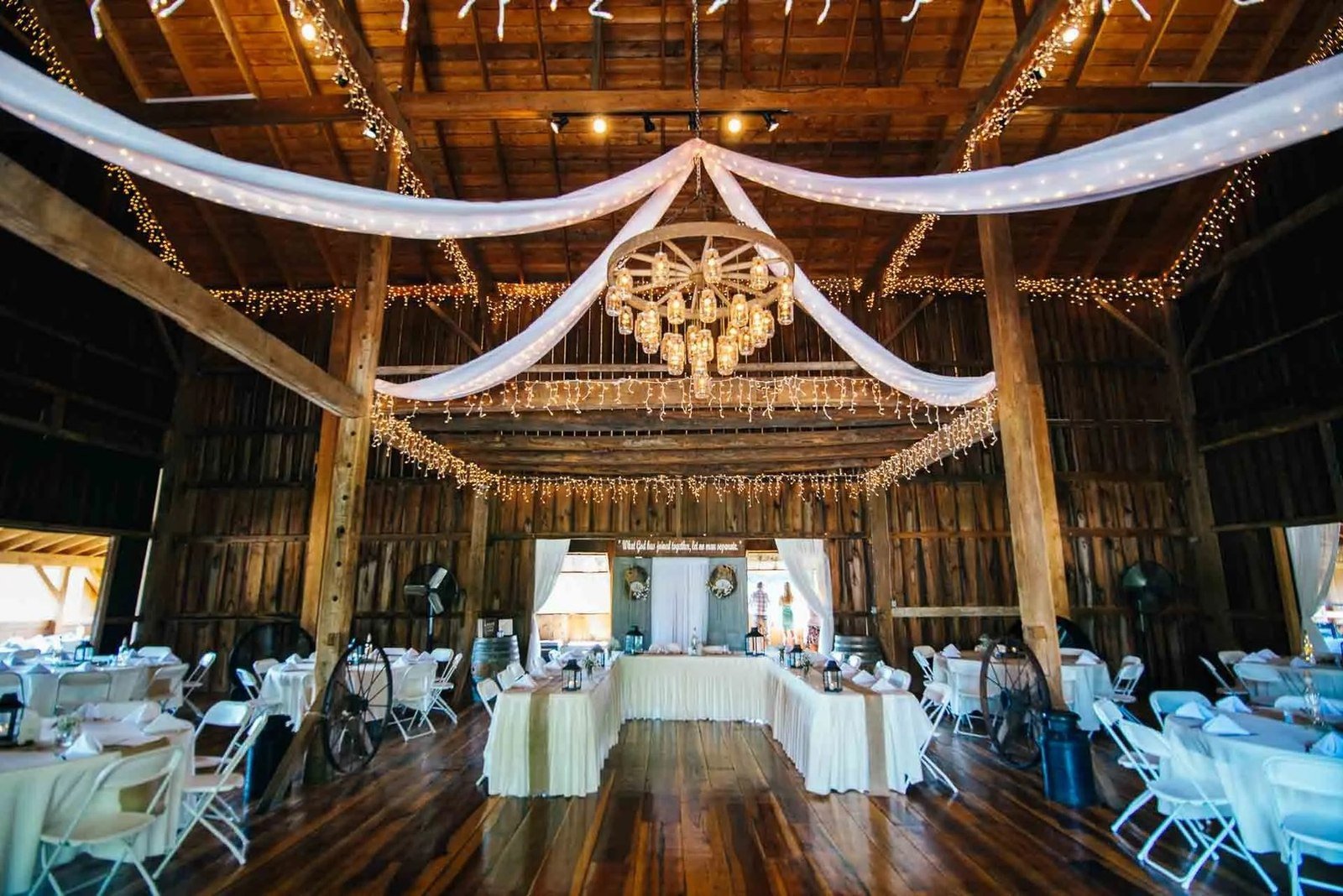 Fairman Family Farms barn interior with mason jar chandelier and white reception setup