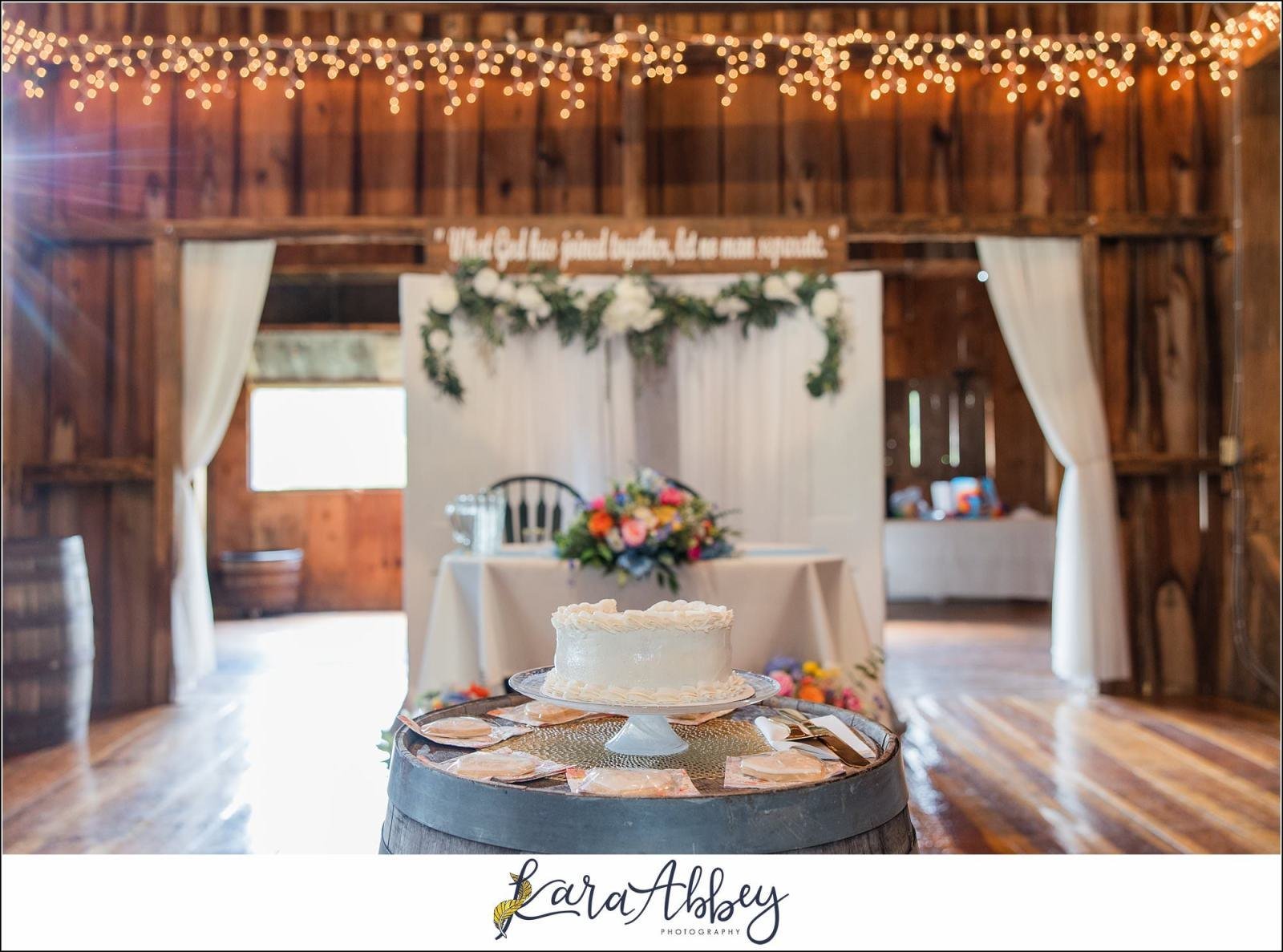 Fairman Family Farms whiskey barrel with wedding cake in barn interior